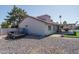 Rear exterior featuring a covered patio, desert landscaping, and access to backyard amenities at 3620 N Aspen Dr, Avondale, AZ 85392