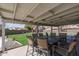Covered patio featuring an outdoor dining set overlooking the backyard and greenery at 3620 N Aspen Dr, Avondale, AZ 85392