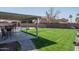Covered patio area with outdoor seating, adjacent to a well-maintained grassy yard and a pool at 3620 N Aspen Dr, Avondale, AZ 85392