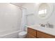 Well-lit bathroom with a shower over the tub, glass shelf, and stylish vanity at 405 E Wescott Dr, Phoenix, AZ 85024