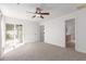 Bright bedroom features neutral carpet, ceiling fan, and access to outdoor patio at 405 E Wescott Dr, Phoenix, AZ 85024