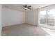 Spacious bedroom with neutral carpet, ceiling fan, and bright window at 405 E Wescott Dr, Phoenix, AZ 85024