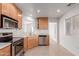 Well-lit kitchen features stainless steel appliances, tile backsplash, and light wood cabinetry at 405 E Wescott Dr, Phoenix, AZ 85024