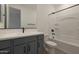 Bathroom featuring grey vanity, white countertop, large mirror and tub with tiled walls at 4050 W Nora Dr, San Tan Valley, AZ 85144
