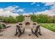 Stone fireplace in backyard featuring two adirondack chairs at 4318 N 180Th Dr, Goodyear, AZ 85395