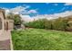 Large grassy backyard featuring a stone fireplace and patio area at 4318 N 180Th Dr, Goodyear, AZ 85395