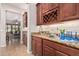 Elegant bar area with granite countertops, wooden cabinets, wine rack, and tile flooring, great for entertaining at 4318 N 180Th Dr, Goodyear, AZ 85395
