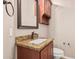 Cozy bathroom featuring granite vanity, sink, framed mirror, and toilet at 4318 N 180Th Dr, Goodyear, AZ 85395