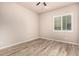 Bedroom featuring light-tone walls, wood-look flooring, and window with blinds at 4318 N 180Th Dr, Goodyear, AZ 85395