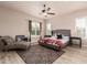 Bright bedroom with a neutral color palette, a patterned rug, a stylish chaise lounge, and a ceiling fan at 4318 N 180Th Dr, Goodyear, AZ 85395