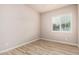 Bedroom featuring light-tone walls, wood-look flooring, and window with blinds at 4318 N 180Th Dr, Goodyear, AZ 85395