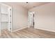 Bedroom featuring light-tone walls, wood-look flooring, and two walk-in closets at 4318 N 180Th Dr, Goodyear, AZ 85395