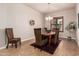 A dining room features a wooden table, wicker chairs, and a stylish chandelier at 4318 N 180Th Dr, Goodyear, AZ 85395