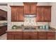 Stylish kitchen featuring granite countertops, dark wood cabinetry, and stainless steel range hood at 4318 N 180Th Dr, Goodyear, AZ 85395