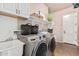 Laundry room with front loading washer/dryer, utility sink, and overhead storage at 4318 N 180Th Dr, Goodyear, AZ 85395