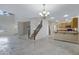 Spacious open-concept living area with tiled floors, staircase, and seamless transition to the kitchen at 5236 N 16Th Ln, Phoenix, AZ 85015