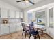 Bright dining area features white cabinets, tile floors, and a rustic wood table beneath a ceiling fan at 5258 E Elena Ave, Mesa, AZ 85206
