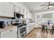 Well-equipped kitchen with stainless steel oven, white cabinets, and tile backsplash, plus adjacent dining nook by window at 5258 E Elena Ave, Mesa, AZ 85206