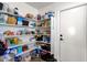 Organized walk-in pantry with multiple shelves, door, and abundant space for storing food and supplies at 5258 E Elena Ave, Mesa, AZ 85206