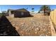 View of the backyard with a large desert rock ground covering surrounded by fencing at 5639 N 46Th Ave, Glendale, AZ 85301