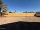 Wide backyard view with a wooden fence, blue sky, and neighboring houses in the distance at 5639 N 46Th Ave, Glendale, AZ 85301