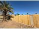 View of the backyard with a wooden fence and palm trees on a sunny day at 5639 N 46Th Ave, Glendale, AZ 85301