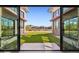 A look at the yard from the house through sliding glass doors with a lush green lawn and adjacent homes at 5848 E Covey Ln, Phoenix, AZ 85054