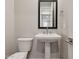 Powder room featuring pedestal sink, a modern mirror, and hardware at 5848 E Covey Ln, Phoenix, AZ 85054