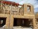 Two-story home under construction, featuring wood framing and a garage, set against a bright, partly cloudy sky at 5848 E Covey Ln, Phoenix, AZ 85054