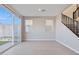 Bright living room featuring tile floors, neutral walls, staircase, and sliding glass doors to the backyard at 5848 E Covey Ln, Phoenix, AZ 85054