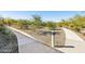 Landscaped walking path through a community with desert-style plants and bright sun at 5848 E Covey Ln, Phoenix, AZ 85054
