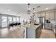 Open-concept kitchen featuring gray cabinets, stainless appliances, island seating, and a seamless transition to dining area at 734 E Doral Ave # 202, Gilbert, AZ 85297