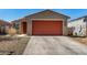 Charming single-story home with a red garage door and well-maintained gravel landscaping at 7456 N 126Th Ln, Glendale, AZ 85307