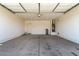 Spacious two-car garage featuring concrete flooring, ample storage, and a secure entry door at 7456 N 126Th Ln, Glendale, AZ 85307