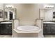 Relaxing bathroom features a soaking tub nestled between two vanities with granite countertops at 7601 E Indian Bend Rd # 2056, Scottsdale, AZ 85250