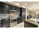Kitchen with granite countertops, stainless steel appliances, black cabinetry, and tile backsplash at 7601 E Indian Bend Rd # 2056, Scottsdale, AZ 85250