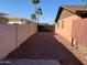 Gated gravel backyard with palm trees and a brick house at 8640 S 16Th Pl, Phoenix, AZ 85042