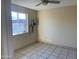 A spacious bedroom with tile flooring with a window, a ceiling fan and a utility box on the wall at 8640 S 16Th Pl, Phoenix, AZ 85042