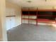 Spacious room with neutral tiled flooring, functional shelving, and a closet for additional storage at 8640 S 16Th Pl, Phoenix, AZ 85042