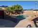Backyard pool surrounded by decorative rock and concrete with tropical palm trees in a fully fenced yard at 8640 S 16Th Pl, Phoenix, AZ 85042