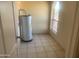 Bright utility room with tile flooring, water heater, and a window providing natural light at 8640 S 16Th Pl, Phoenix, AZ 85042