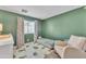 Bedroom with green walls, wood-look floors, and natural light from a window at 8760 W Meadow Dr, Peoria, AZ 85382