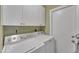 Laundry room with a white washer and dryer and storage cabinets above at 8760 W Meadow Dr, Peoria, AZ 85382
