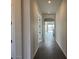 Inviting hallway featuring dark tile flooring, neutral wall colors, and elegant archway leading to living areas at 10039 W Verde Ln, Avondale, AZ 85392