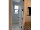 Hallway with a window, white trim, and open doorway with a light wood vanity ready for fixtures and finishing at 10039 W Verde Ln, Avondale, AZ 85392