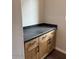 Laundry room featuring wooden cabinets, black hardware, and a gray countertop for folding and storage at 10039 W Verde Ln, Avondale, AZ 85392