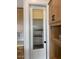 Well-organized pantry with a decorative glass door, offering ample storage space next to the kitchen cabinets at 10039 W Verde Ln, Avondale, AZ 85392