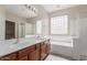 Bright bathroom with a dual sink vanity, soaking tub, and a separate glass shower at 10287 S 175Th Ave, Goodyear, AZ 85338