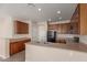 Well-lit kitchen features wooden cabinetry, stainless steel sink, and tiled flooring at 10287 S 175Th Ave, Goodyear, AZ 85338