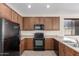 This kitchen features wooden cabinetry and black appliances at 10287 S 175Th Ave, Goodyear, AZ 85338